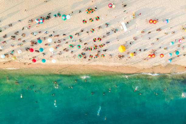 vista aérea de una playa llena de gente, sombrillas y gente en la arena - miami beach fotografías e imágenes de stock