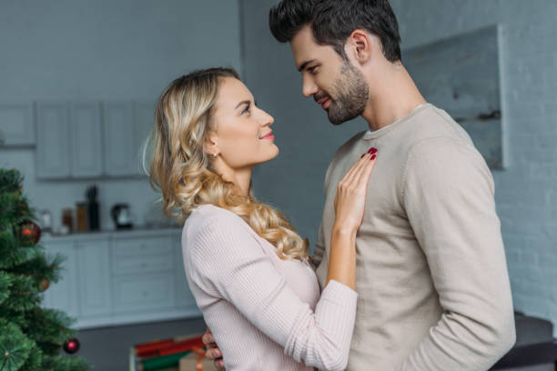 affectionate couple hugging in kitchen and looking at each other