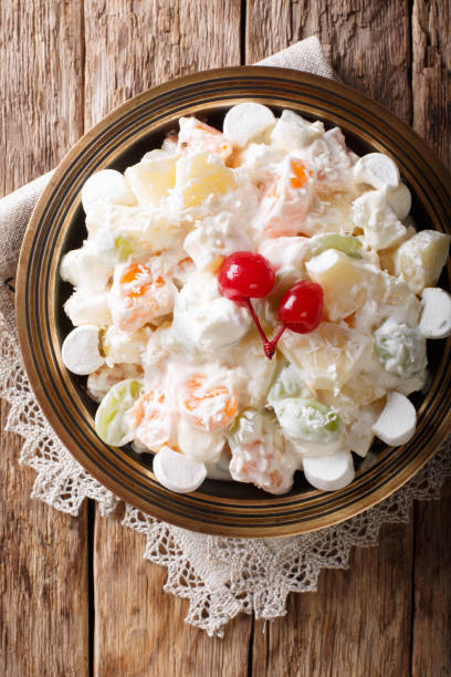 istock Light fruit salad Ambrosia with marshmallow and vanilla yogurt close-up. Vertical top view 1059204786