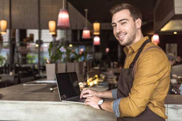 istock handsome young waiter using laptop a bar counter in cafe 1059205162