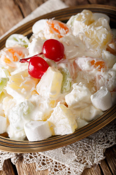 istock fruit salad Ambrosia from pineapple, tangerine, grapes and marshmelow close-up. vertical 1059205232
