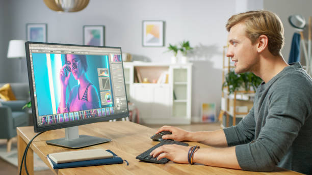 istock Professional Photographer Works in Photo Editing App / Software on His Personal Computer. Photo Editor Retouching Photos of Beautiful Girl. Mock-up Software Design. 1059208434