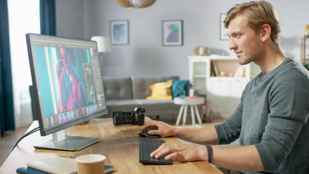 istock Professional Photographer Works in Photo Editing App / Software on His Personal Computer. Photo Editor Retouching Photos of Beautiful Girl. Mock-up Software Design. 1059208464