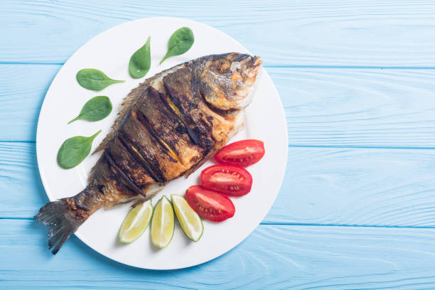 istock Fried fish dorado with lime , tomatoes and spinach 1059208502