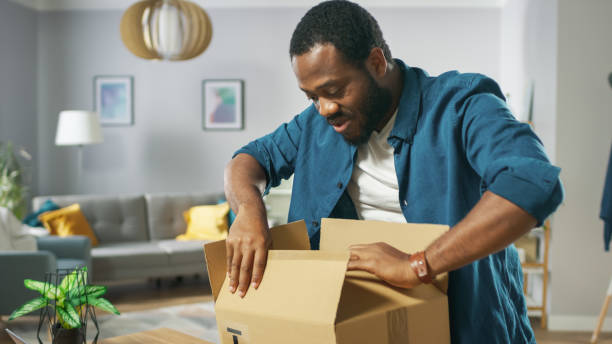 Handsome Excited Man Opens Cardboard Box Postal Package and Is Very Happy with Content. Man Package Unboxing.