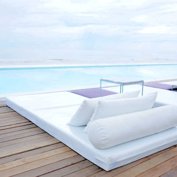istock Modern beach bed on swimming pool deck in resort, summer vacation concept 1059213958