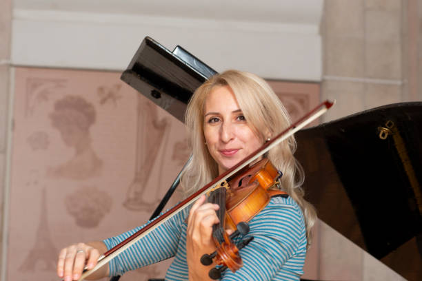 istock Young positive blonde playing violin 1059216716