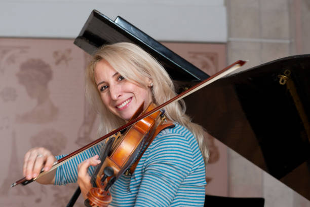 istock Young positive blonde playing violin 1059216936