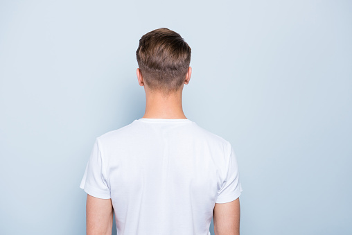 Back rear view photo of confident, attractive, nice-looking man isolated on light blue background