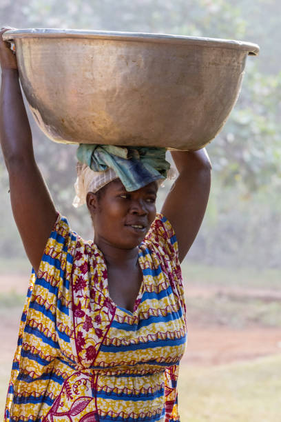Ghana, Accra - January 02, 2017: African Ghana woman carries a container full of water on the head in Accra, Ghana
