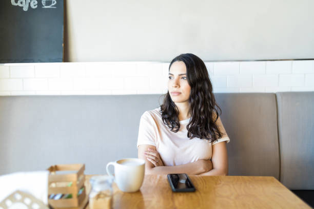 コーヒー ショップで彼氏を期待しながら期待して女性 - stood up ストックフォトと画像