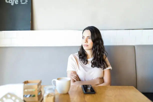 Photo of Woman Anticipating While Expecting Boyfriend In Coffee Shop