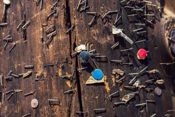 Close-Up Of Wooden Telegraph Pole With Colored Rusty Staples And Ripped Pieces Of Paper stock photo