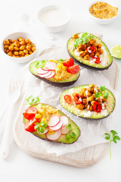 istock avocado boats stuffed with hummus, tomatoes, radish, roasted chickpea 1059235156