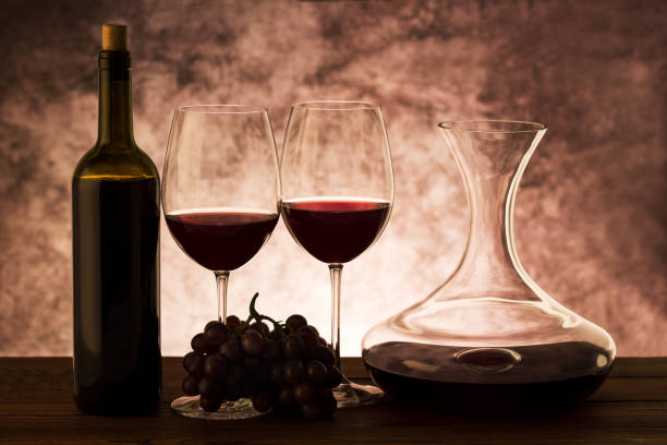 istock Red wine. Two glasses of red wine, grapes and decanter on table 1059245256