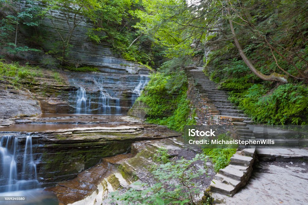 Trail and Cascades A stone stair follows a series of cascades.  Summer within the gorge of Buttermilk Falls Park. Ithaca - New York State Stock Photo