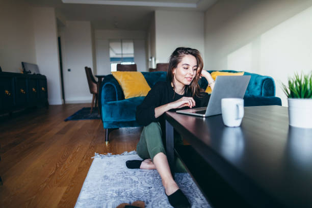 young woman using laptop at home - telecommuting technology equipment one person imagens e fotografias de stock