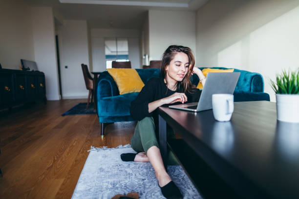 м�олодая женщина с помощью ноутбука в домашних условиях - buying shopping computer cup стоковые фото и изображения