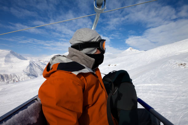 istock Skier on cable car and snow ski slope 1059248518