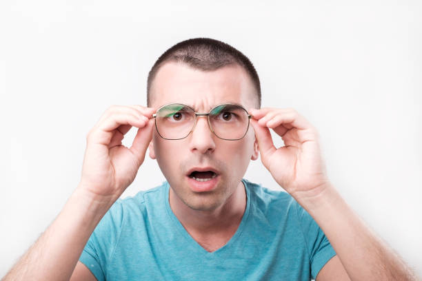 istock Young handsome man in glasses thinking in doubts and touching lips on gray. 1059257980