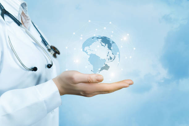 A female doctor with a stethoscope on her neck is holding a crystal, sparkling global map on her hand . A female doctor with a stethoscope on her neck is holding a crystal, sparkling global map on her hand against the blue sky background. soil health stock pictures, royalty-free photos & images