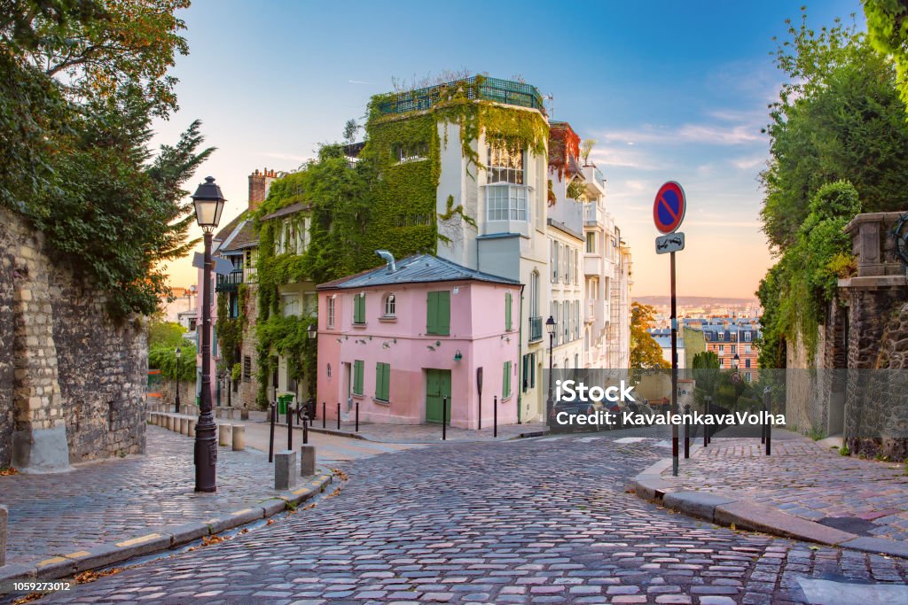 Montmartre in Paris, France Cozy old street with pink house at the sunny sunrise, quarter Montmartre in Paris, France Paris - France Stock Photo