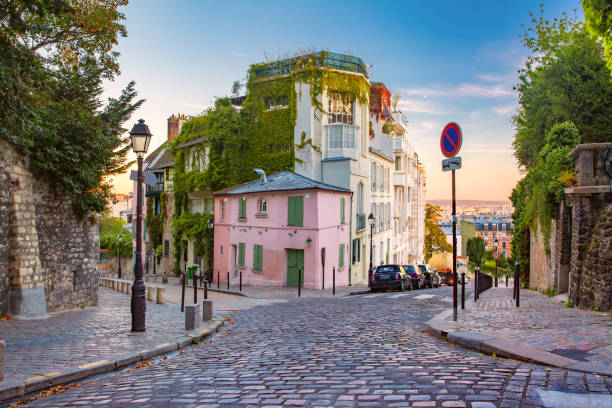 Montmartre in Paris, France Cozy old street with pink house at the sunny sunrise, quarter Montmartre in Paris, France ile de france photos stock pictures, royalty-free photos & images