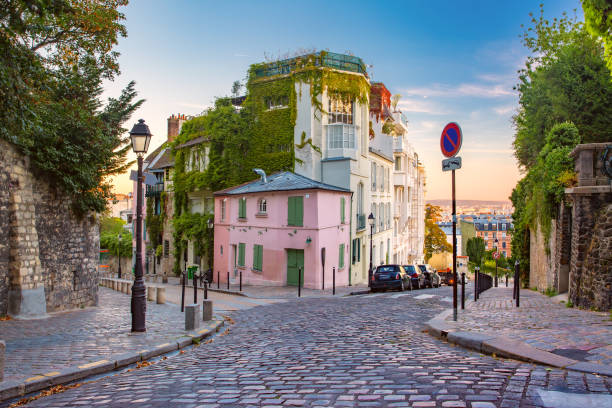 Montmartre in Paris, France Cozy old street with pink house at the sunny sunrise, quarter Montmartre in Paris, France montmartre stock pictures, royalty-free photos & images