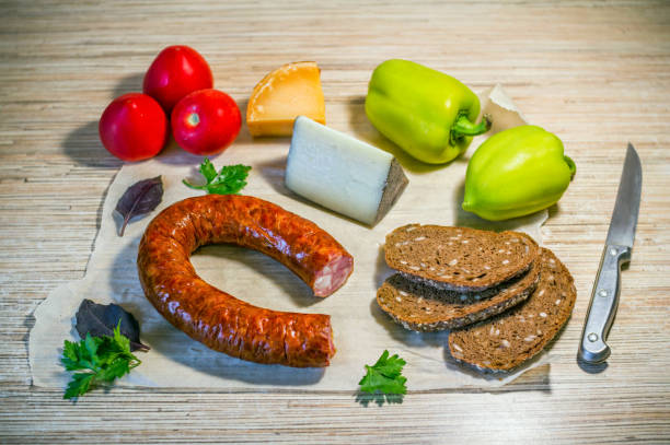 istock Products on the table – smoked sausage, brown bread, cheese and vegetables 1059275748