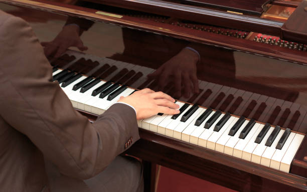istock Handsome young men playing piano at the restaurante 1059277812
