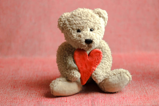 istock Teddy bear holding plasticine heart 1059278058