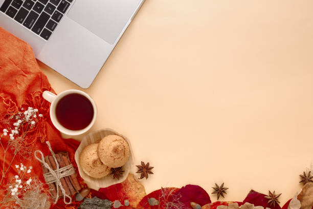 istock autumn leaves, scarf and laptop on yellow background 1059281166