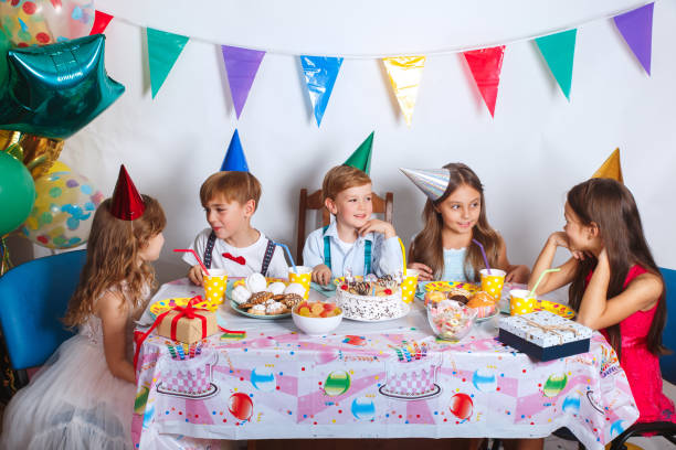 うれしそうなのほとんどのグループは、自宅で祝う誕生日パーティーを子供します。飾られた部屋で子供たちの面白おかしい誕生日パーティー - child party group of people little girls ストックフォトと画像