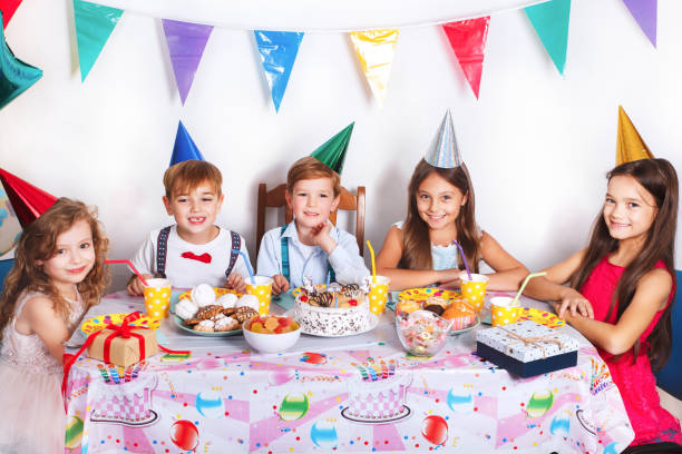 うれしそうなのほとんどのグループは、自宅で祝う誕生日パーティーを子供します。飾られた部屋で子供たちの面白おかしい誕生日パーティー - child party group of people little girls ストックフォトと画像