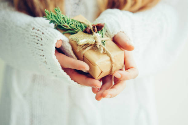 istock Woman's hands hold christmas or new year gift box. 1059288596