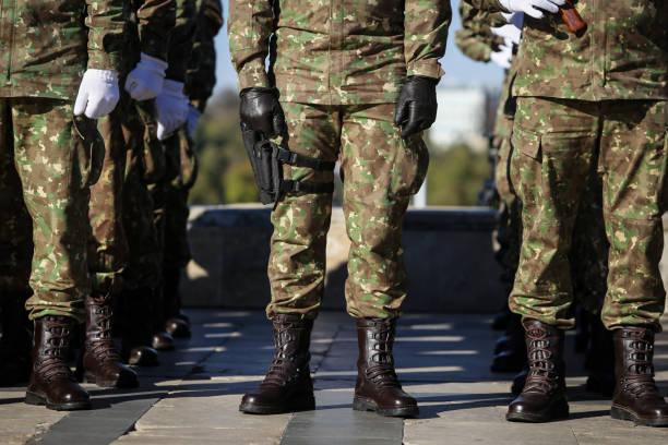 details with the uniforms, gloves, boots and handguns of soldiers - combat boots imagens e fotografias de stock