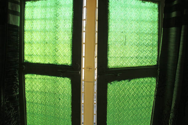 istock Green windows from old vintage glass with floral or geometric patterns. Ancient shutters. India, Hampi 1059292524
