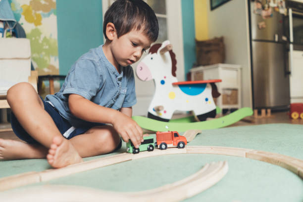 istock Cute little boy playing with wooden train 1059296318