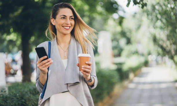 istock Happy woman walking and texting 1059296322