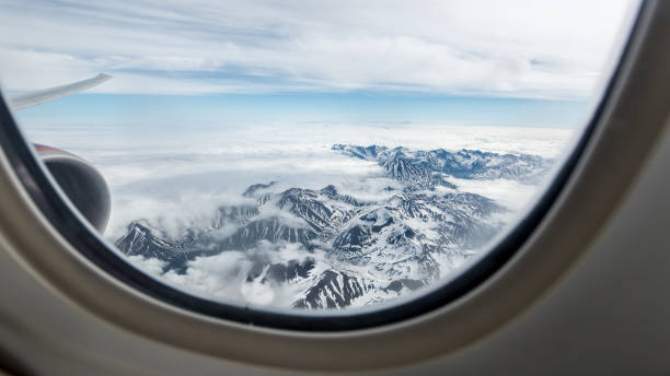 Beautiful view of the Kamchatka mountains from the airplane porthole. Beautiful view of the Kamchatka mountains from the airplane porthole. stratosphere airplane cloudscape mountain stock pictures, royalty-free photos & images