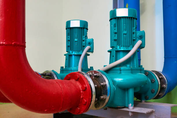istock Two vertical engines painted blue with pumps connected to pipes painted red and blue. 1059302164