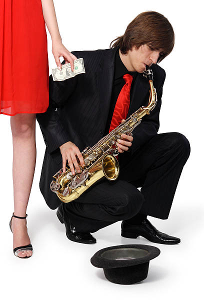 Girl alms to a man who plays the sax stock photo