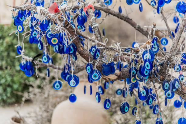 accrocher les yeux bleus de mal (nazar boncugu) sur l’arbre - nazar boncugu photos et images de collection