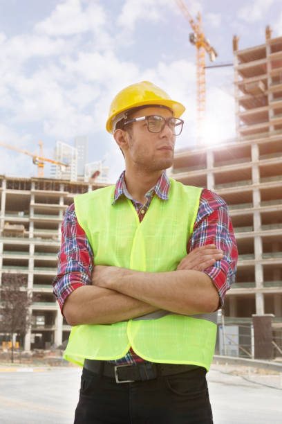 istock Young Engineer portrait with construction site and crane background. 1059309074
