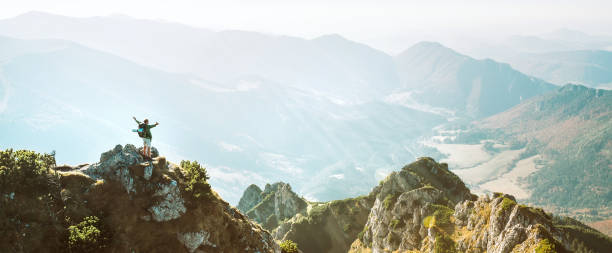 istock Mountain hiker with backpack tiny figurine stands on mountain peak with beautiful panorama 1059309252