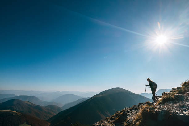 istock Backpacker hiker on the mountain hill in contrast sun light 1059309258