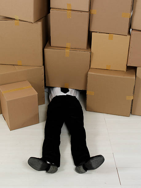 istock A man in a suit laying on the floor under cardboard boxes 105931404