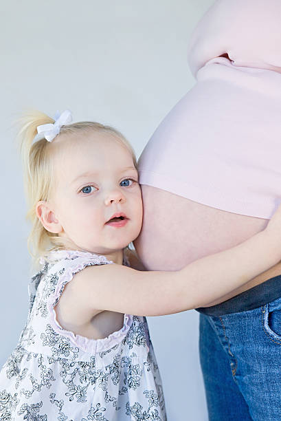 istock Little Girl Hugging Mom's Belly 105931599