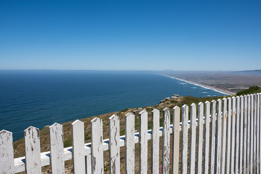 White picket fence and the Point Reyes National Seashore shoreline of Marin County California