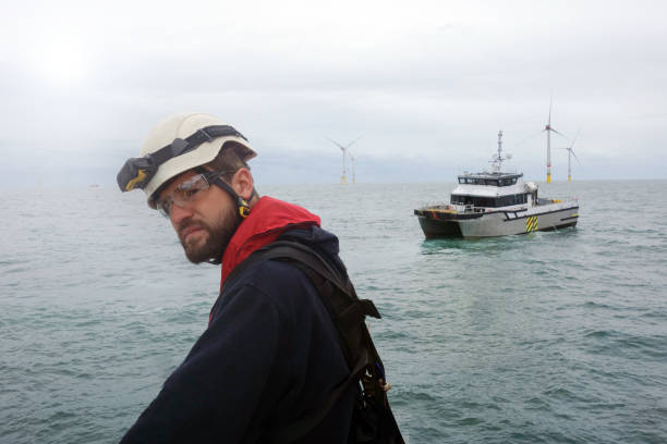 istock Offshore manual workers waiting for boat and looking on wind turbines 1059321200